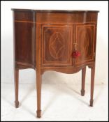 An Edwardian mahogany inlaid serpentine fronted side cabinet / work table. The hinged top with