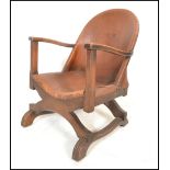 An early 20th Century open framed tub armchair, upholstered in brown tan leather with studded detail
