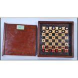 An early 20th Century travelling chess game set, within a wooden case with sliding lid and turned
