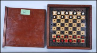 An early 20th Century travelling chess game set, within a wooden case with sliding lid and turned