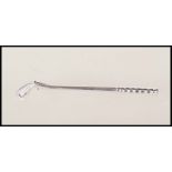 A stamped 18ct white gold brooch in the form of a golf club. Weight 3.1g. Measures 5.5cm long.