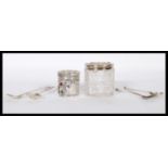 A pair of silver hallmarked and cut glass dressing table pots with rococo silver tops together