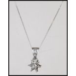 An 18ct white gold diamond necklace pendant in the form of  a starset with a diamond adorned bale