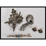 A collection of silver brooches together with a pair of Art Deco style silver earrings. The brooches