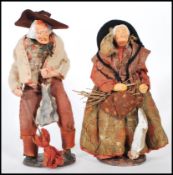 A pair of pottery made Simone Jouglas figures in the form of an old man and women farmers, the