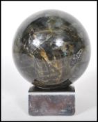 A labradorite specimen precious stone sphere on a chromed metal base. Measures approx 9cm diameter.