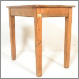 A vintage early 20th century chunky country pine scrub top dining table being raised on squared legs