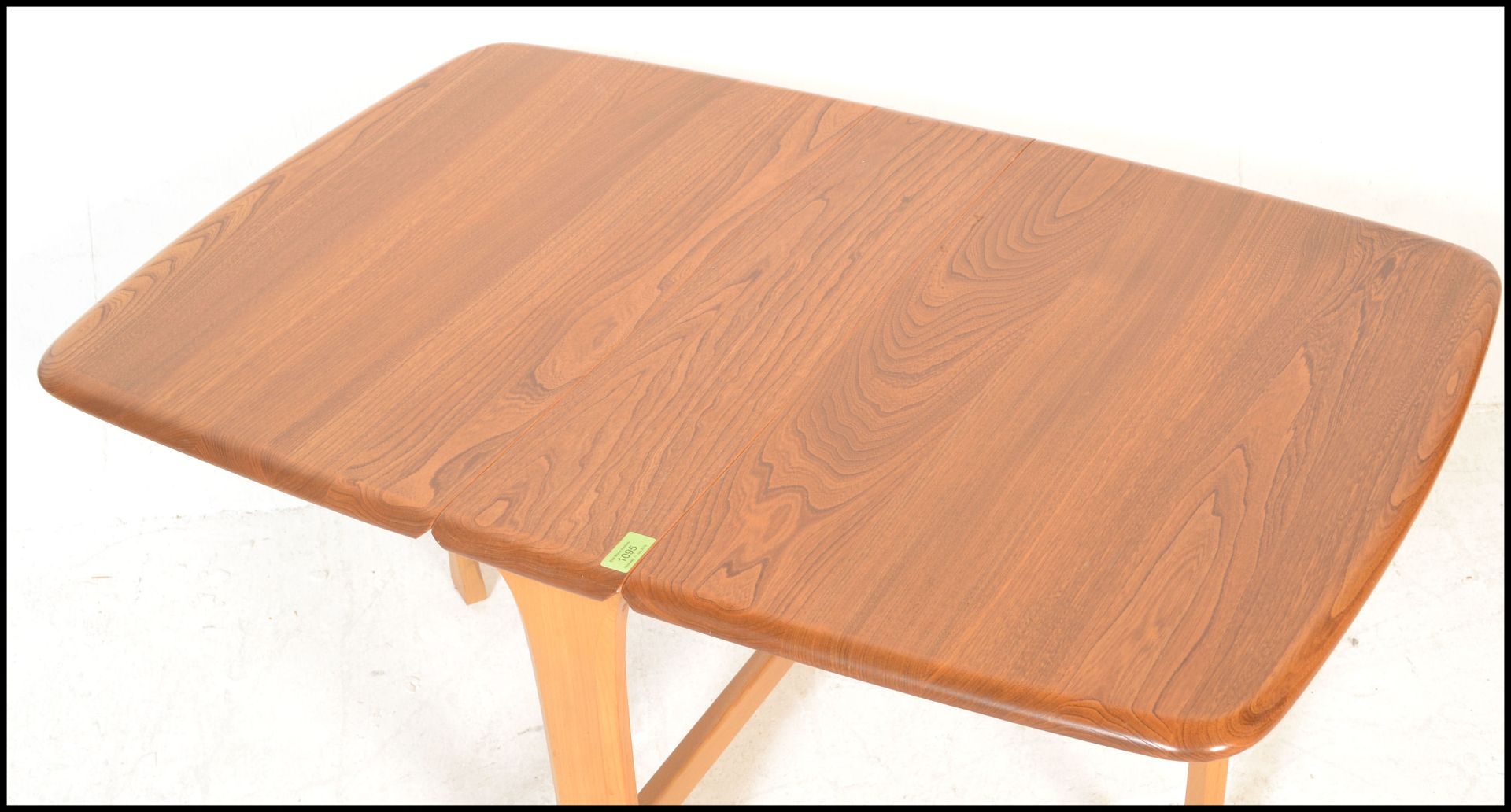 An Ercol beech and elm wood light drop leaf sutherland occasional - coffee table being raised on - Bild 4 aus 5