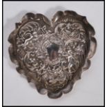 A silver hallmarked rococo heart shaped pin dish, the heart shaped dish decorated in relief with