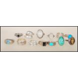 A collection of silver rings to include two moonstone cabochon rings, a tigers eye cabochon ring,