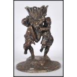 A cast bronze centrepiece epergne base depicted with two cherubs holding up floral garland decorated