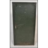 A vintage Industrial metal locker cabinet having green military paint work. The full length door