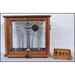 AN early 20th Century mahogany glazed cased apothecary / chemists scales by Griffin and George,