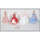 A collection of four ceramic figurines of ladies to include an early Royal Doulton figurine ' Top o'