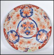 A large 18th /19th Century Chinese export Imari charger decorated with bold vase of flowers and