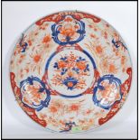 A large 18th /19th Century Chinese export Imari charger decorated with bold vase of flowers and