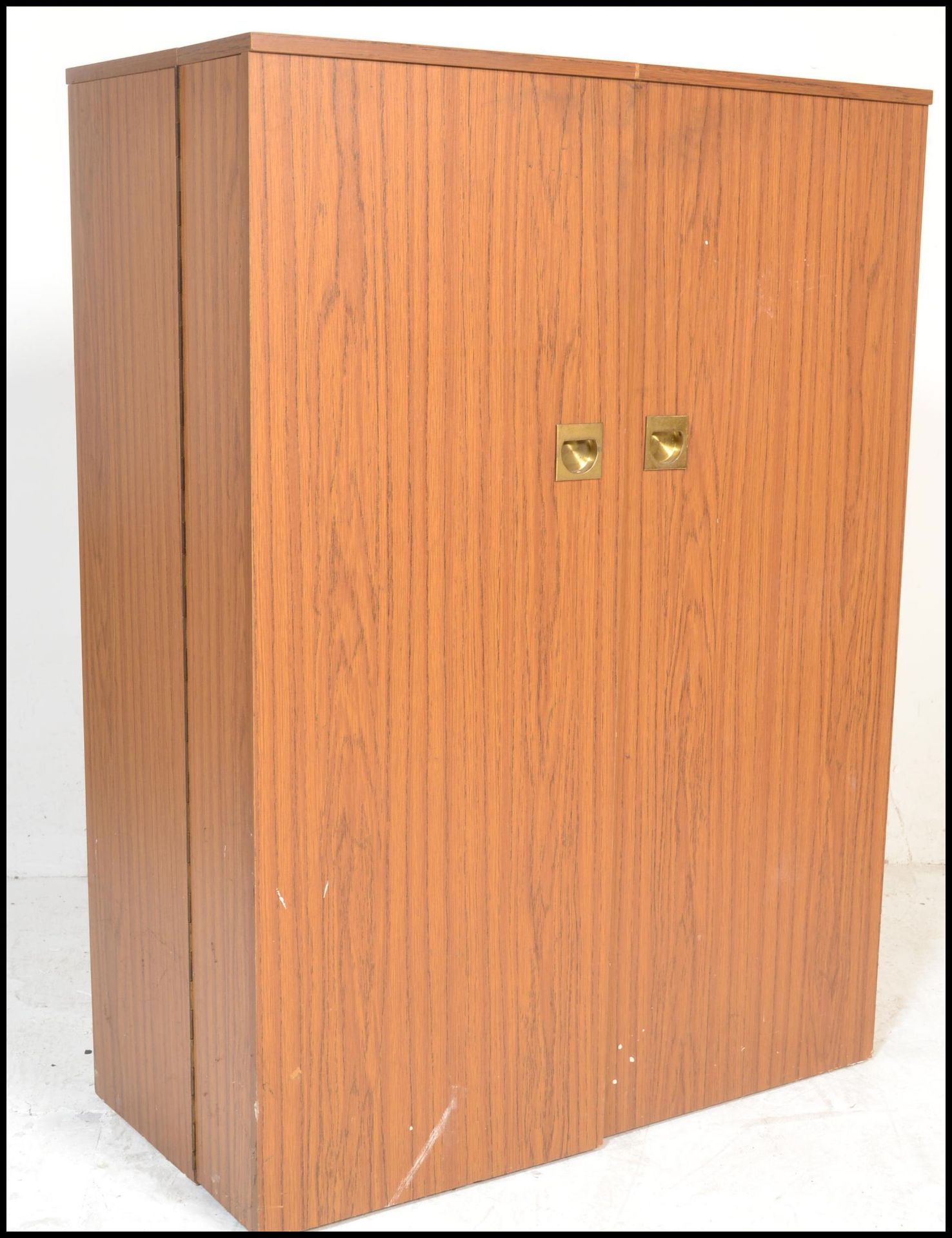 A 1970’s retro cube desk cabinet. Faux teak wood veneers with brass campaign  handles opening to
