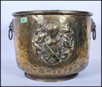 A late 19th Century high Victorian brass twin lion mask coal scuttle / log basket, armorial crest in