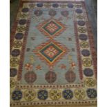 A 20th Century oriental woven blue ground geometric floor rug having a central blue panel with a
