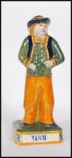 A 19th Century French Victorian ceramic faience figurine of a brightly glazed gentleman in had
