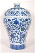 A large Chinese Kangxi blue and white baluster vase decorated with scenes of peony flowers with