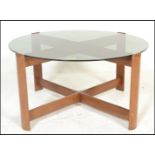 A mid century retro teak wood and smoked glass circular coffee - occasional table. Raised on