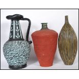 A group of three 20th Century studio pottery vases and a jug. One vase of tapering form having red