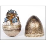 A silver hallmarked Stuart Devlin limited edition surprise egg having a textured exterior opening to