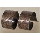 A pair of 20th Century hallmarked silver napkin rings of unusual open scrolled form having