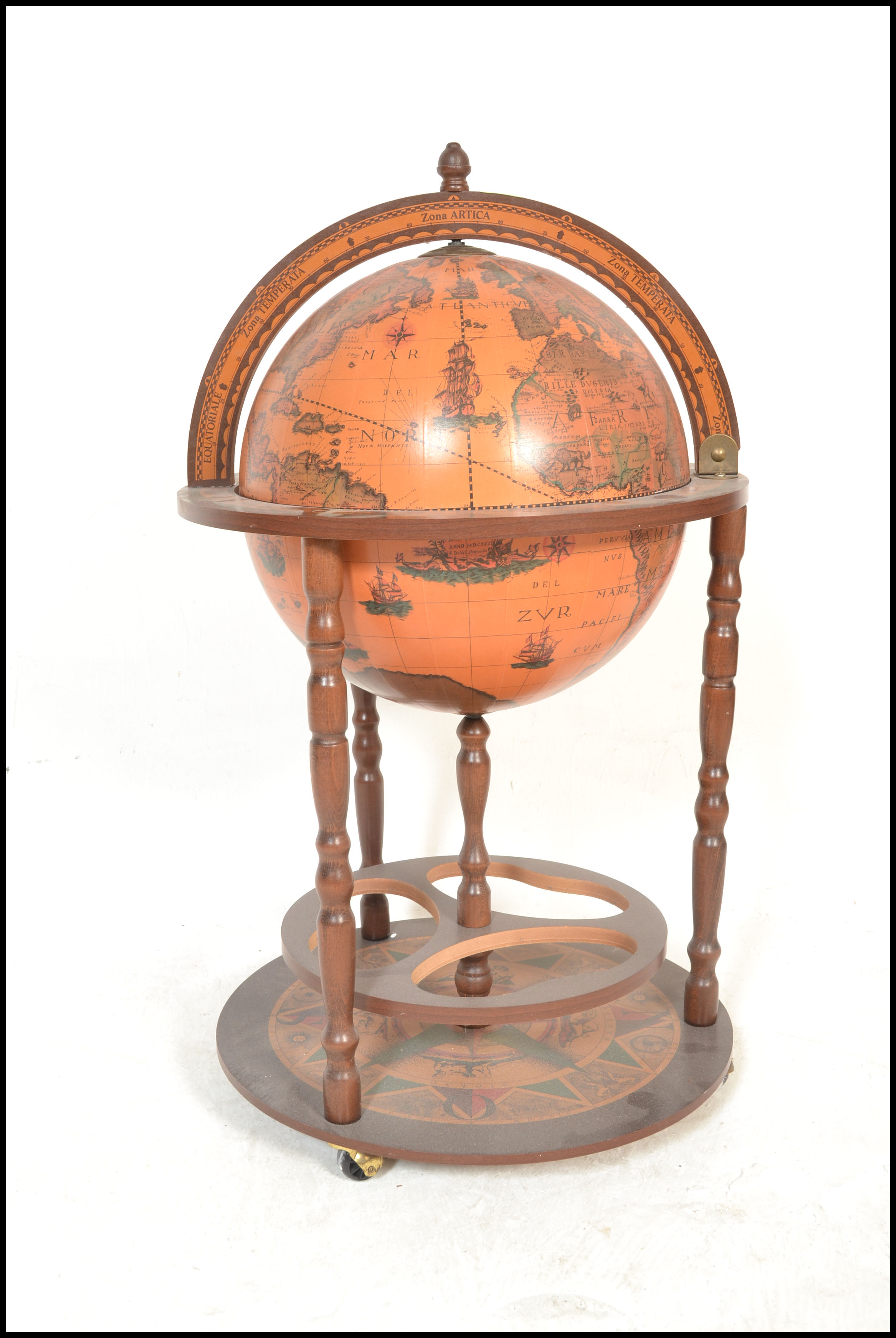 An antique style floor standing cocktail drinks cabinet in the form of a terrestrial globe with