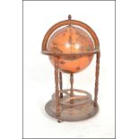 An antique style floor standing cocktail drinks cabinet in the form of a terrestrial globe with