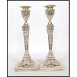 A pair of  late Victorian silver hallmarked large filled candlesticks having square terraced bases