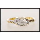 A stamped 18ct gold and platinum Art Deco cross over ring illusion set with three round cut