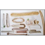A group of gold tone jewellery necklaces and decorative bangles, various designs to include flat