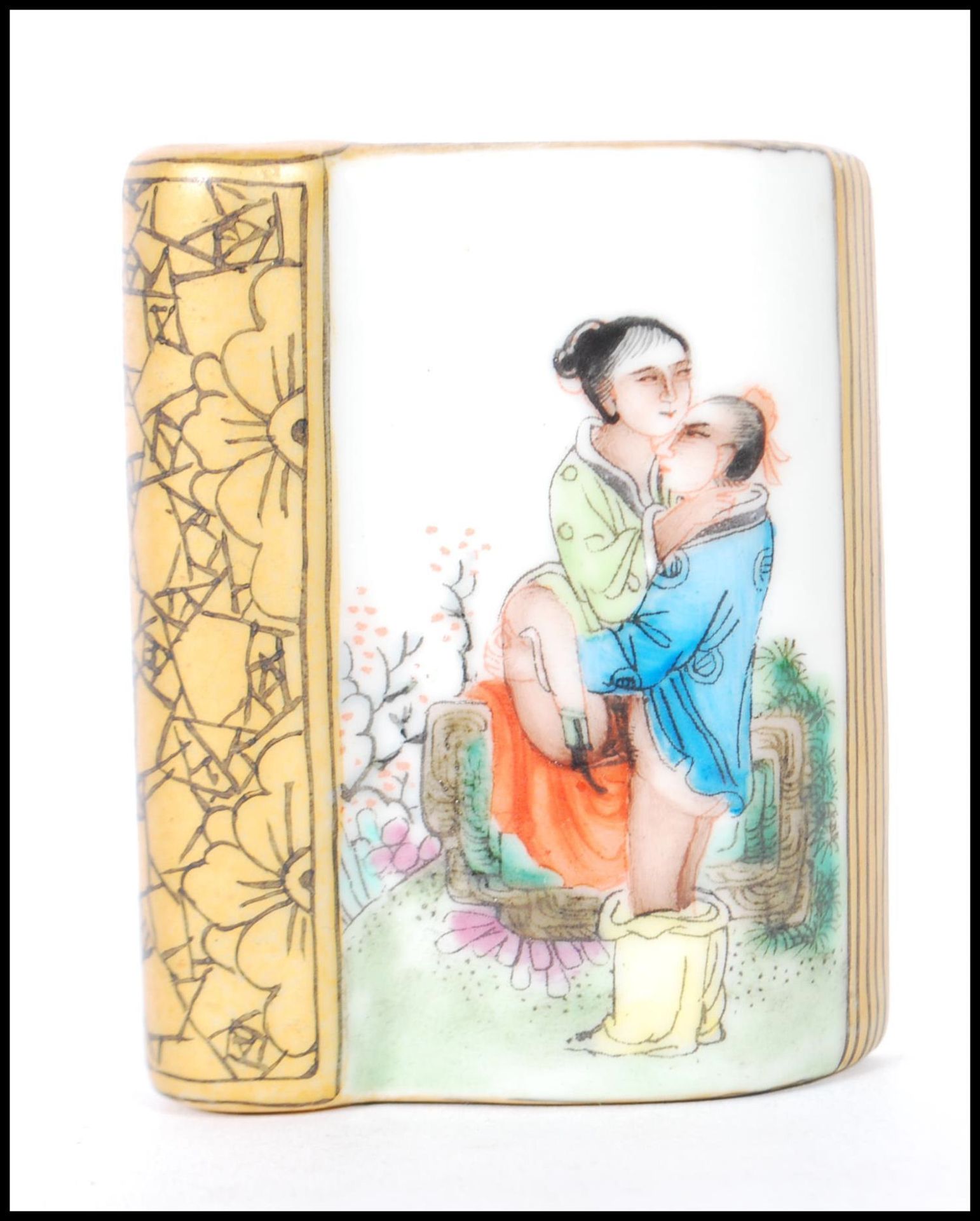 A 20th Century Chinese paperweight in the form of a book having an erotic scene with gilt details.