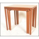 A retro 20th Century Danish teak wood nest of three graduating occasional tables raised on shaped