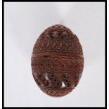 A 20th Century carved coquilla nut pomander case being carved with concentric circle patterning with