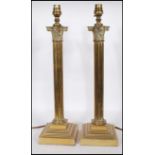 A matching pair of 20th Century brass corinthian column lamps of typical form raised on stepped