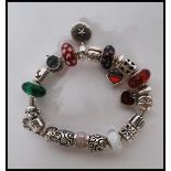 A stamped 925 silver Pandora charm bracelet having a snake chain with 17 silver charms and safety