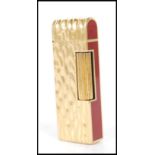 A vintage Dunhill cigarette lighter having burgundy enamelled panels to the ends with a gilt bark