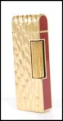 A vintage Dunhill cigarette lighter having burgundy enamelled panels to the ends with a gilt bark