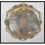 A silver hallmarked salver tray by Mappin & Webb being raised on claw and ball feet. Hallmarked