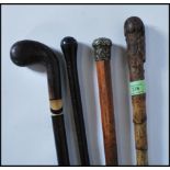A group of three walking stick cannes to include a bamboo stick having a silver white metal knop,