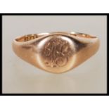 An early 20th Century hallmarked 9ct gold signet ring having a round panel to the head engraved