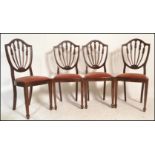 A set of four 20th Century mahogany Hepplewhite style dining chairs, drop in seat pads raised on