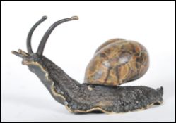 A cast bronze sculpture ornament in the form of a snail having a cold painted shell, signed to the