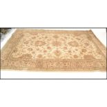 A 20th Century Persian Islamic rug having a beige ground with floral decoration to the central panel