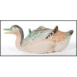 An early 20th Century Japanese Banko ware teapot in the form of a duck, being hand painted with