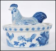 A Chinese blue and white chicken crock pot having cover in the form of a chicken with foliat