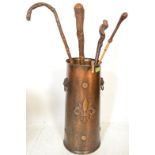 A vintage 20th Century hand worked copper stick stand together with a selection of walking canes and